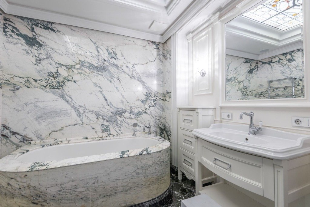 Marble bathroom with a freestanding bath and book matched stone