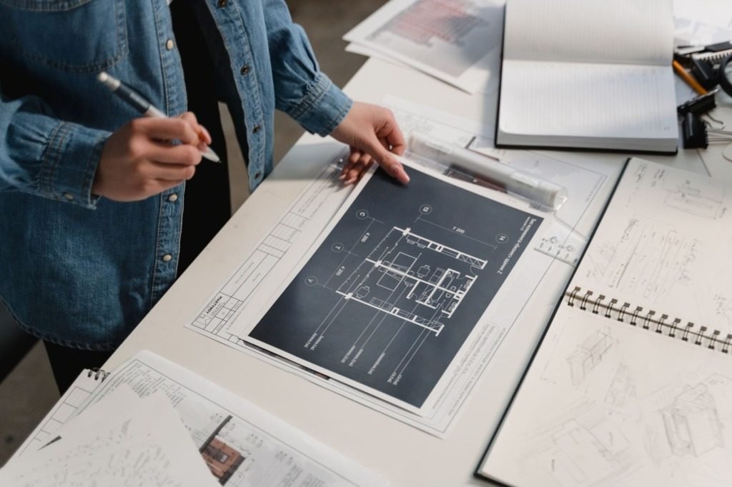 Interior designer cost in Cairo -- hands over architectural drawings at a desk