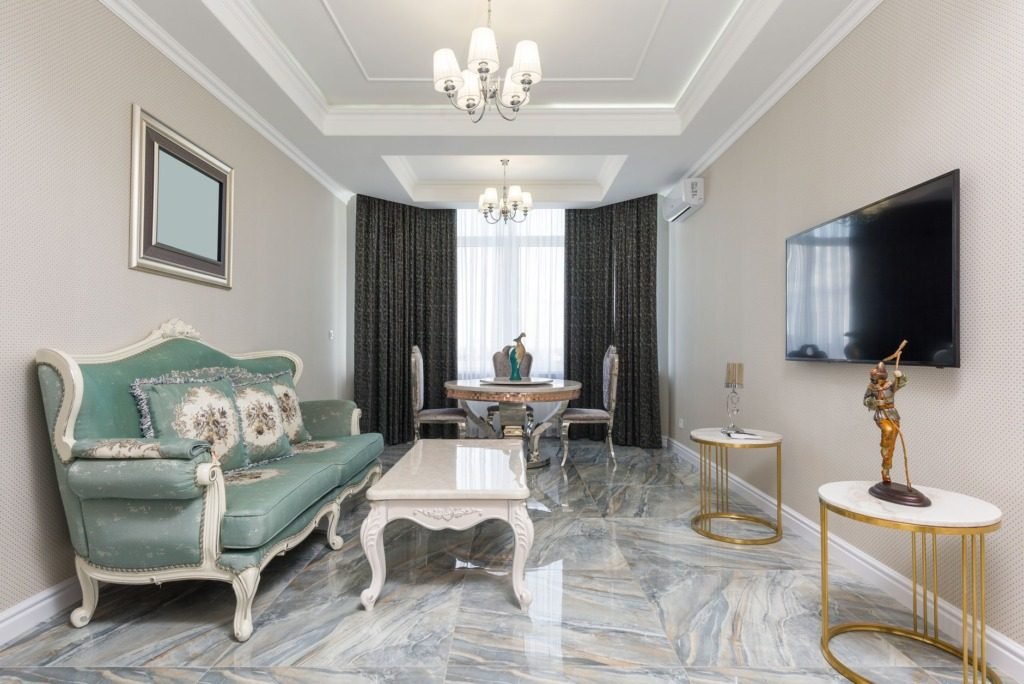 Interior designer or decorator styling in a classic Cairo living room with chandelier and upholstered chairs
