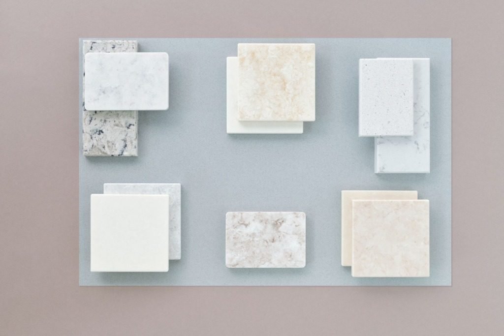 Marble tile samples arranged on a neutral surface, interior finishes that age well in Cairo