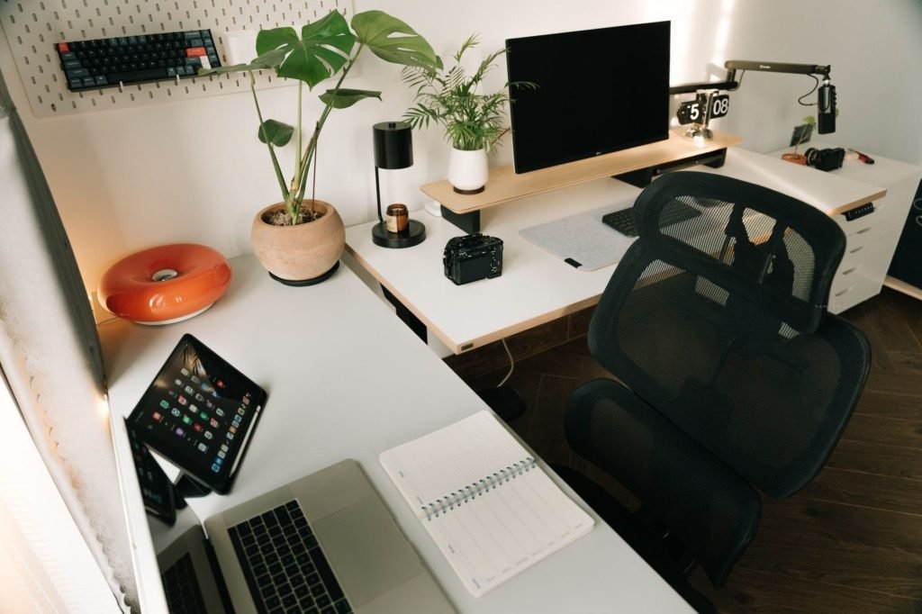 Home office desk with a laptop, monitor and plants, interior designer cost in telal