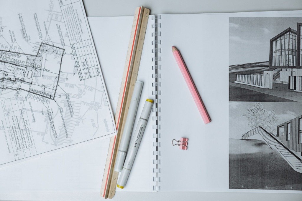 Architectural drawings and measuring tools on a desk, the planning work behind interior designer cost in New Cairo