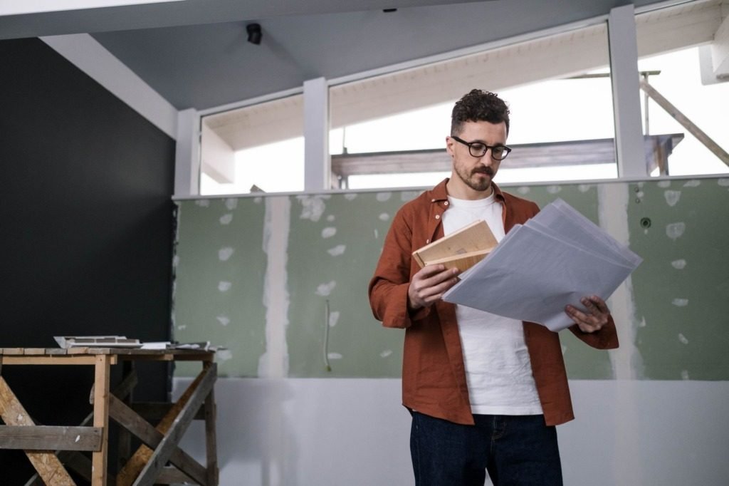 Designer reviewing drawings on site during a renovation