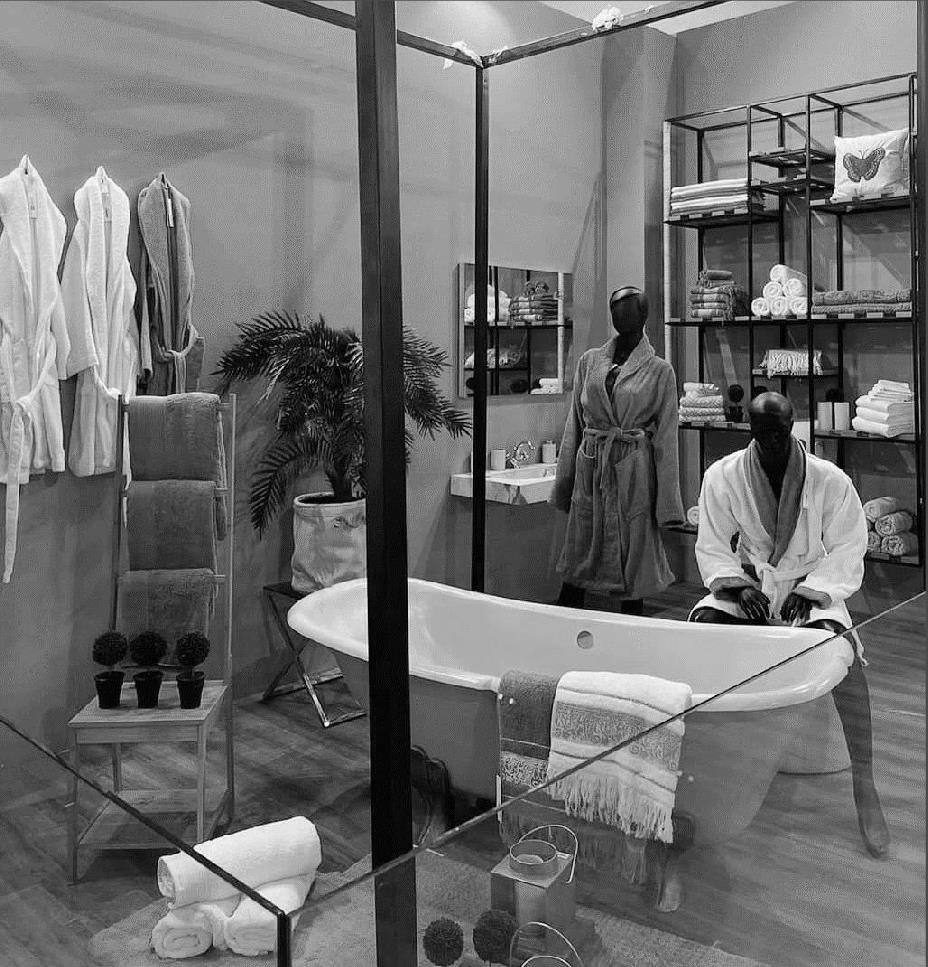 Boutique showroom display with freestanding rails and a feature bath, retail interior design Cairo