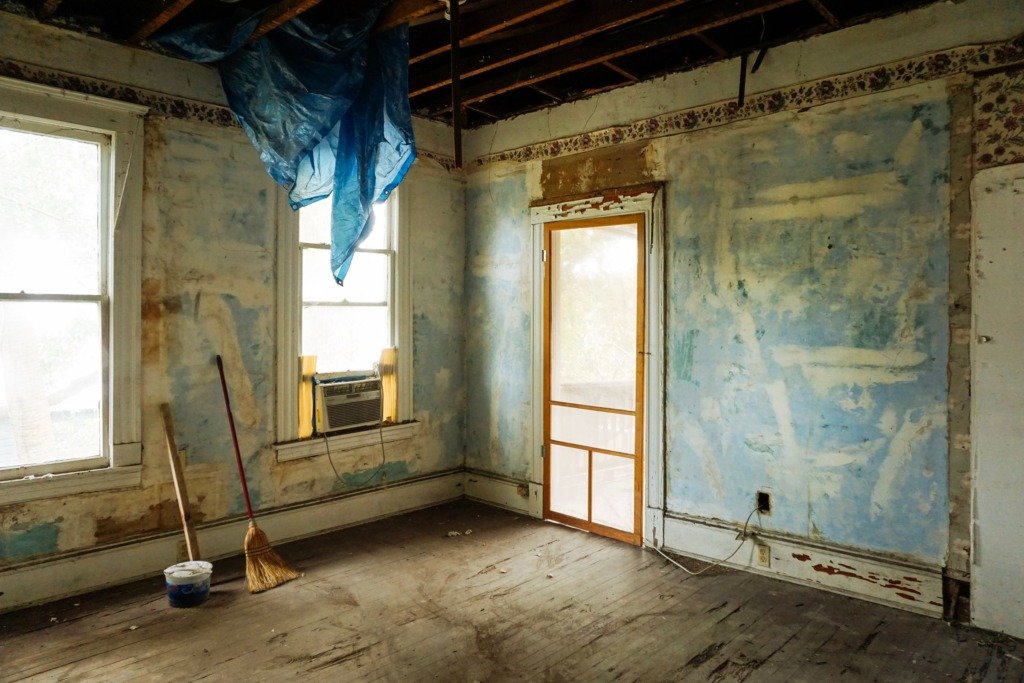 An empty room in an abandoned house with peeling walls and construction tools, renovating an old apartment in Cairo