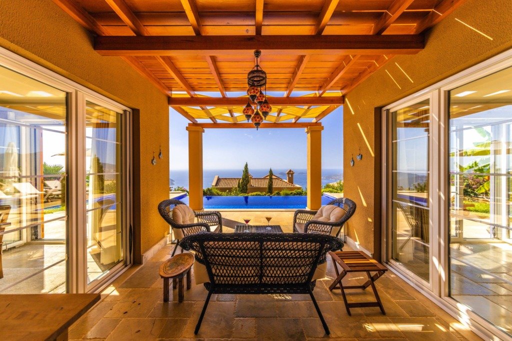 Relaxing patio at a luxury villa with sea view, featuring rattan furniture and infinity pool, north coast chalet interior design