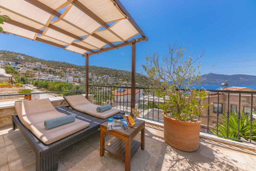 Relaxing terrace with sunbeds offering a scenic sea view in a summer setting.
